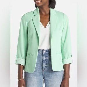 Mint colored fitted blazer with rolled sleeves.